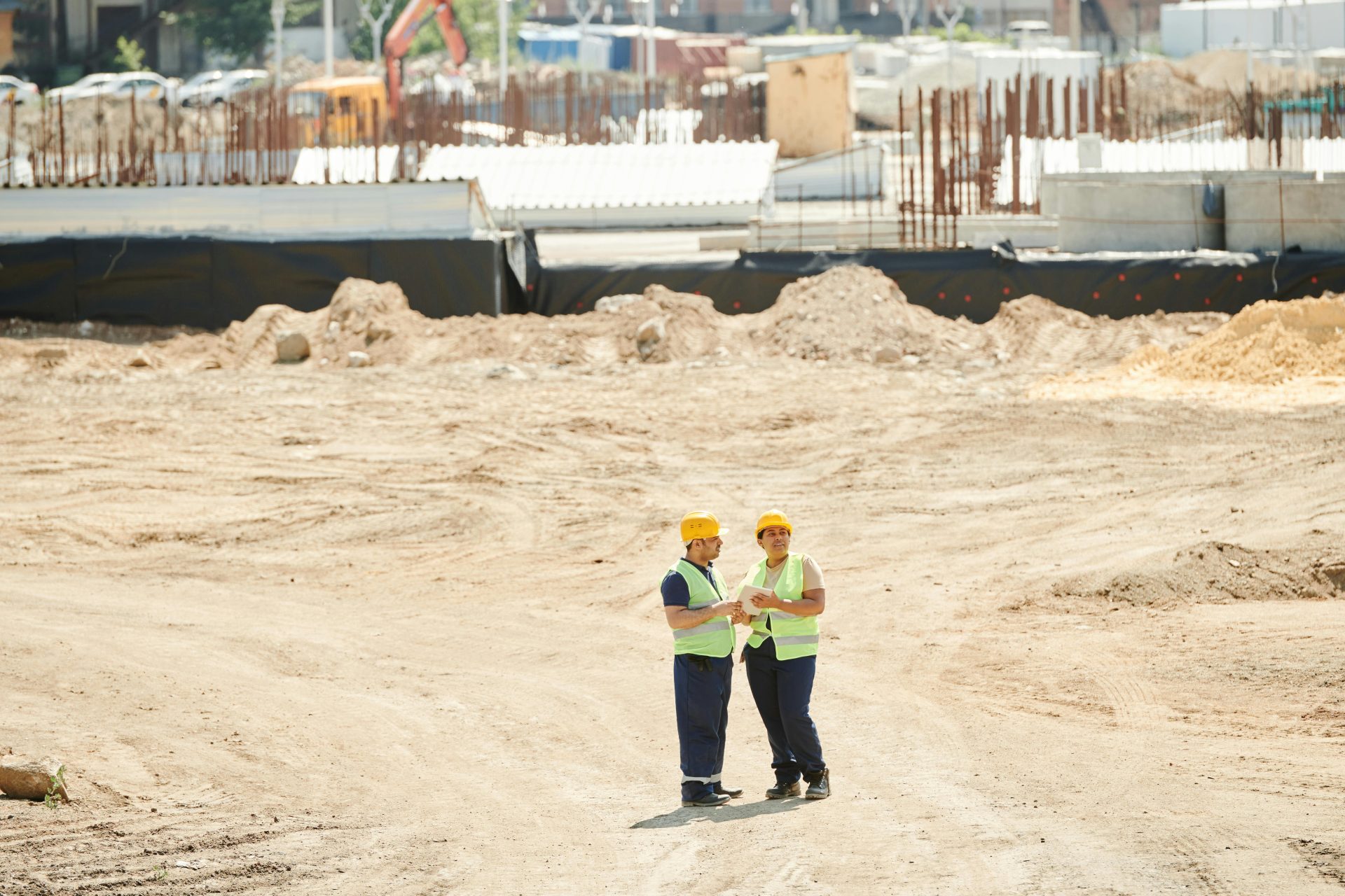 Conducteur de travaux effectuant un suivi de chantier sur tablette avec plans et tableaux de bord, gestion de projet de construction BTP